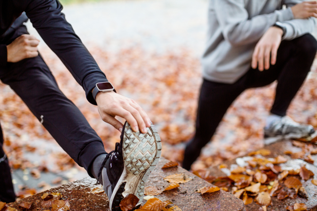 Menschen in Sportkleidung dehnen sich in der Natur.
